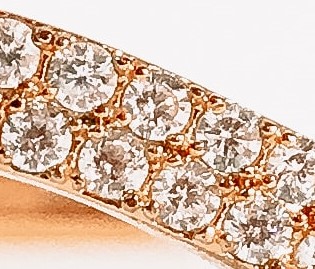 Fotografía de un acercamiento a diamantes incrustados en metal dorado como oro 