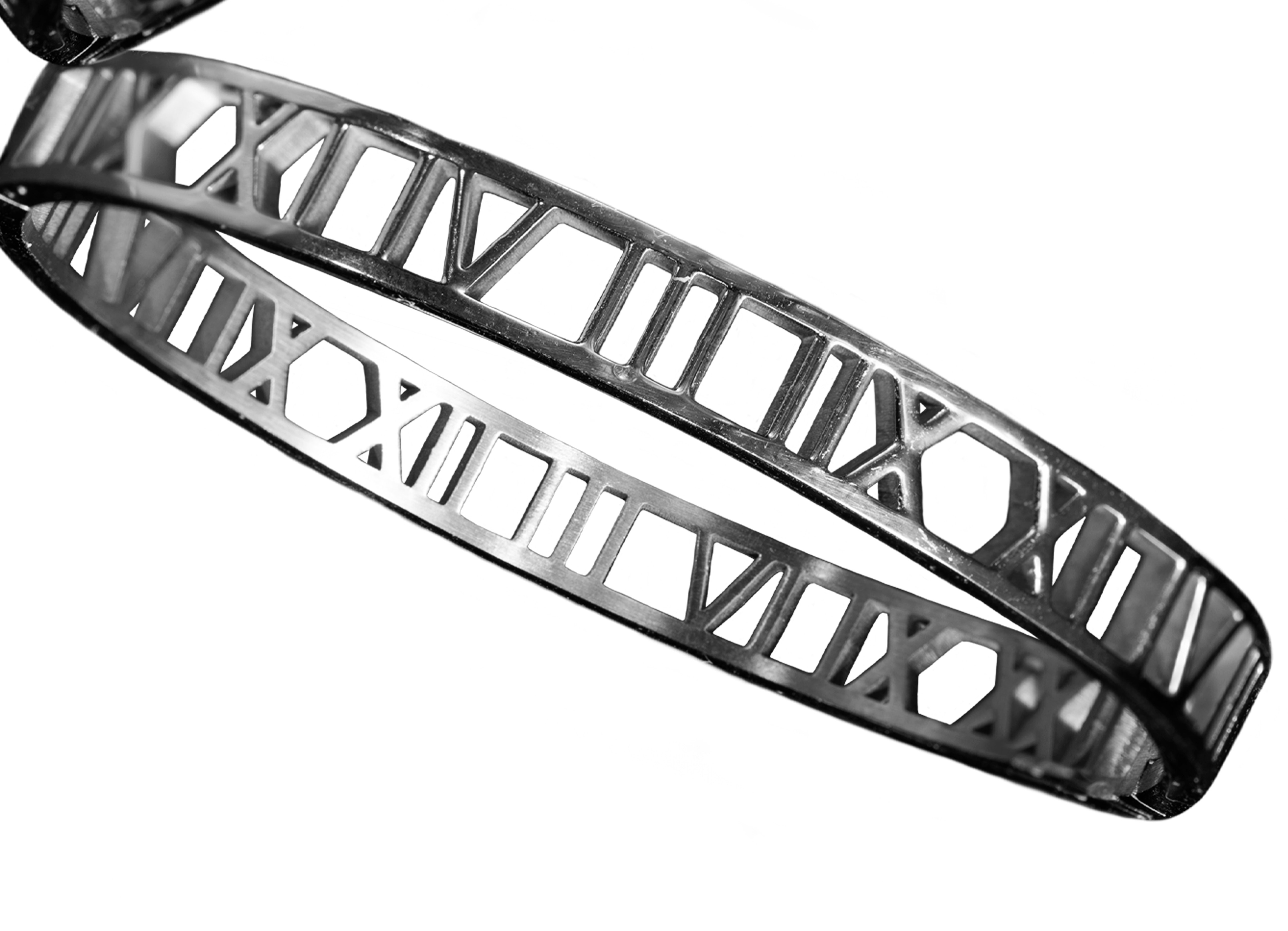 Fotografía de una parte de dos brazaletes de metal plateado con diseño de numeros romanos 