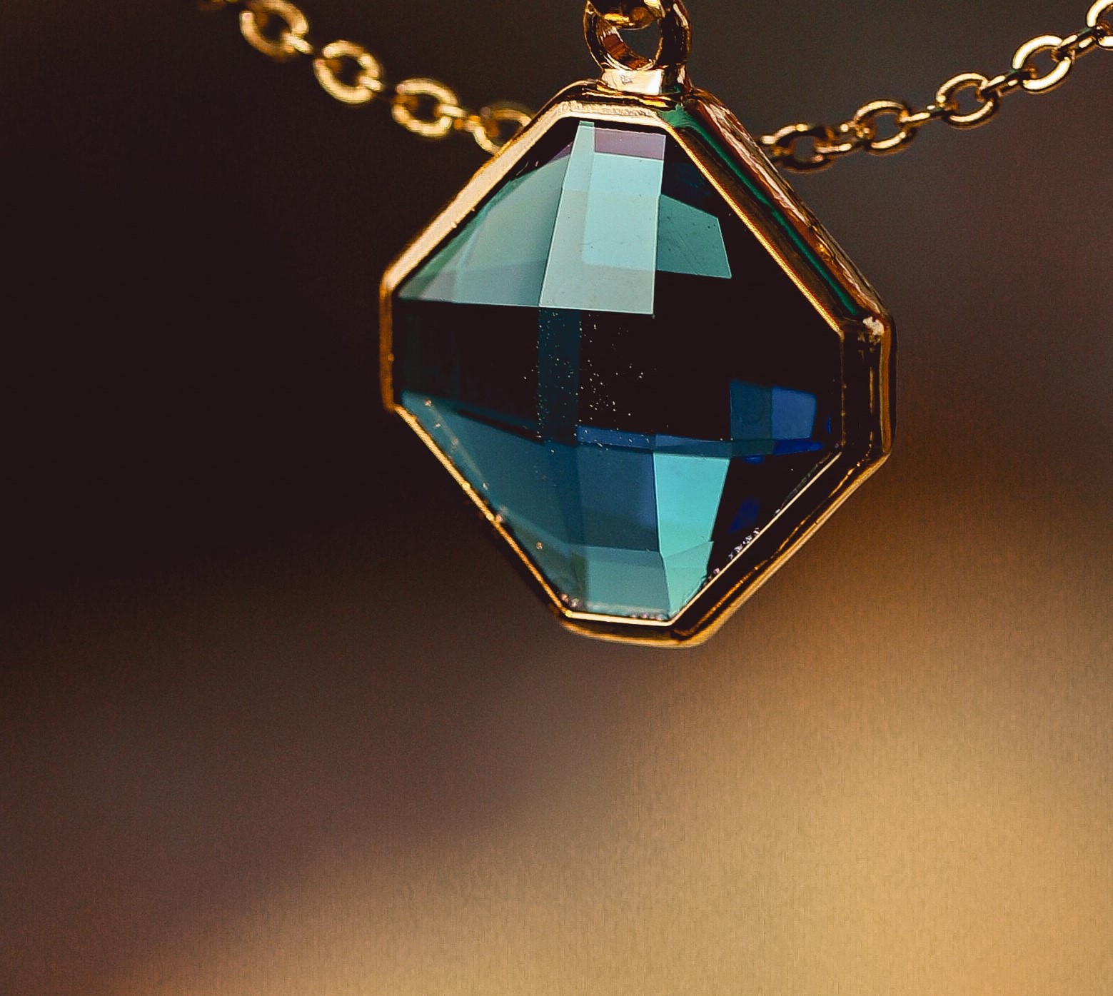 Fotografía de pieza de un collar en forma de rombo con diamante azul 