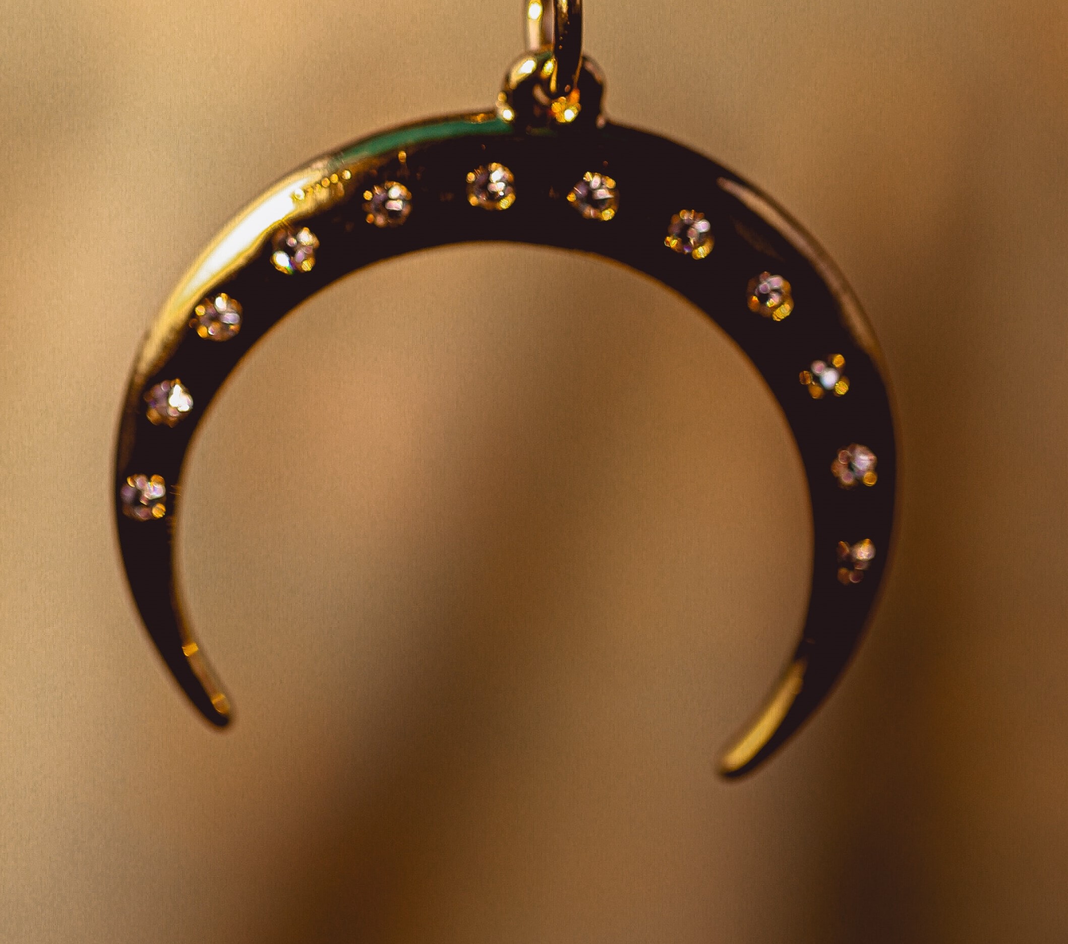 Fotografía de pieza de un collar en forma de luna con diamantes incrustados